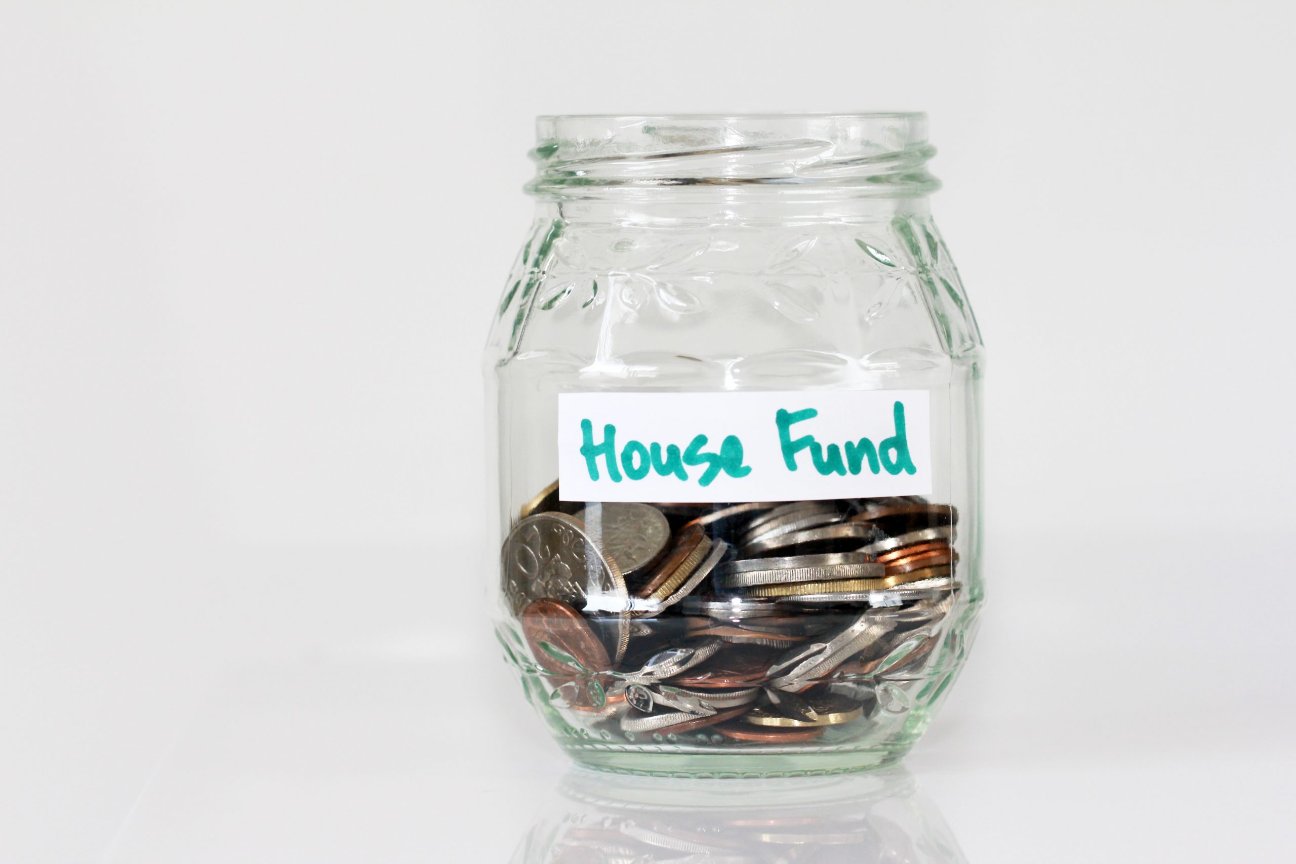 Picture of savings jar filled with money and labelled house fund